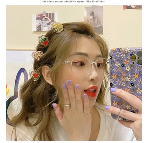 Mini mollette per capelli in metallo con frutti come limone e fragola in un selfie allo specchio