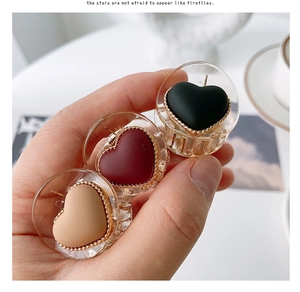 Mini heart-shaped hair claw clips set in black, red and beige with gold metal trim edges