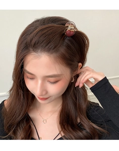 Close-up of red matte heart hair claw clip worn on model hair side view accessory