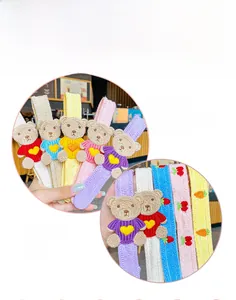 Detail view of five colorful knitted bear hair clips with embroidery for kids