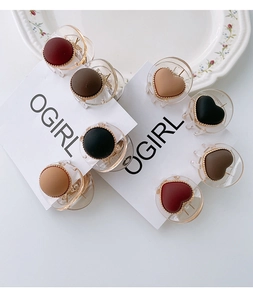 Detailed close-up of heart hair clips with matte finish and gold spherical bead edges