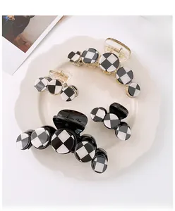 Detailed set of black and white checkerboard hair claws in various sizes on a tray