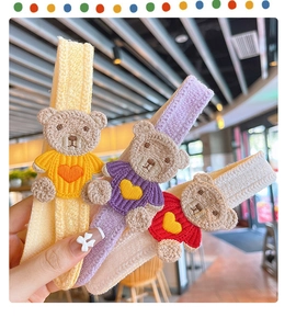 Detailed embroidery of three cartoon bears on knitted magic hair clips in red, yellow and purple