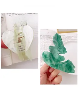 Vue détaillée des pinces à cheveux en acétate en forme de cœur et de feuille marbrée