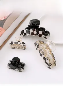 Detailed set of checkerboard hair claws in black and white on a minimalist white tray