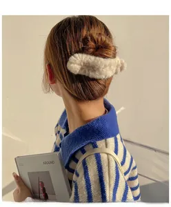 Détail d'une pince à cheveux en peluche beige moelleuse pour une coiffure d'automne douillette