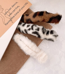Vue détaillée de barrettes en fausse fourrure à motif léopard, pois et blanc crème