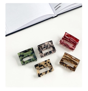 Close-up of five acetate rectangular hair claws with marble and tortoiseshell patterns