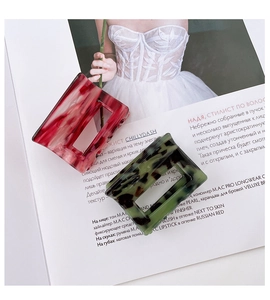 Detail of square acetate hair claws in marble pink and tortoise green patterns