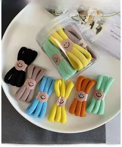 Set di elastici per capelli colorati ad alta elasticità con barattolo su piatto bianco