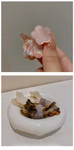 Mini pinces à cheveux fleuries en résine rose et écaille de tortue dans un bol blanc
