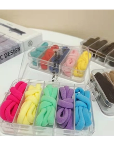Primo piano di elastici per capelli colorati in un organizzatore a scomparti trasparenti