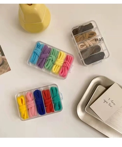 Dettaglio di elastici per capelli colorati organizzati in una scatola a cinque scomparti trasparenti