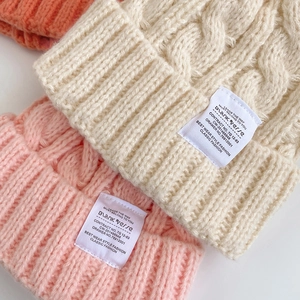 Winter chunky cable knit beanies in cream white and pink colors with stylish square labels