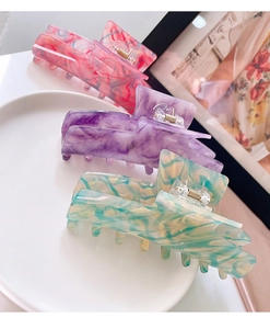 Detailed set of three marble textured acetate hair claws in pastel pink and purple tones