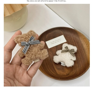 Détail de barrettes ours en peluche sherpa avec nœuds à carreaux en marron et blanc