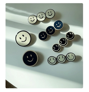 Vista macro dettagliata di fermagli per capelli smiley trendy con finitura lucida e bordi in metallo