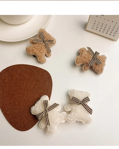 Détail de quatre barrettes ours en peluche avec nœuds à carreaux en crème et marron