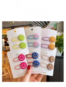 Detailed view of colorful fabric-wrapped hair clips with smiley face button charms