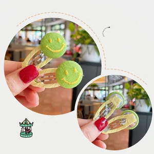 Green fabric BB hair clips with yellow embroidered smiley face for kids, two-piece set