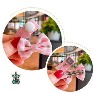 Floral and polka dot bow hair clips for girls featuring pink fabric and crown logo