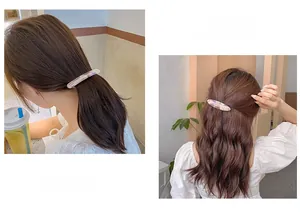 Detail of marble pattern acetate spring hair clip on model in a half-up ponytail style