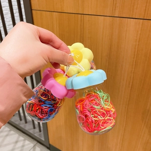 Three jars of colorful elastic hair bands in gourd-shaped bottles with sunflower caps