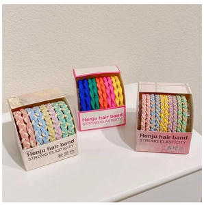 Detail of colorful high elasticity braided hair ties in candy-colored paper packaging