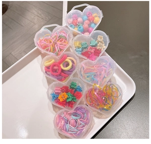 Détail de l'ensemble d'élastiques colorés et pinces fleurs dans des boîtes en forme de cœur