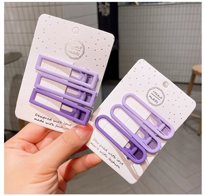 Vista dettagliata di fermagli per capelli viola opachi su carta bianca fatta a mano