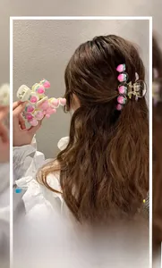 Détail de la pince à cheveux pêche avec cœurs roses et ressort doré brillant