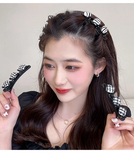 Gros plan de barrettes à carreaux noir et blanc pour tresses et coiffage latéral