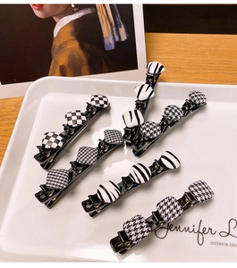 Lot de 6 barrettes à motifs damier et pied-de-poule sur un plateau en céramique