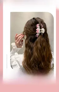 Vue détaillée de la pince à cheveux blanche avec nœuds roses en résine sur modèle