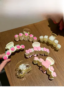Gros plan de pinces à cheveux en acrylique rose avec motifs pêche et ours sur bois