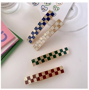 Detail of four checkered hair clips featuring vintage hammered gold metal texture and finish