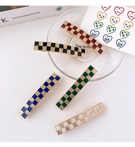 Detail of colorful checkerboard hair clips with gold alloy base and enamel finish