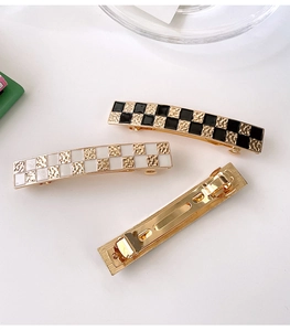 Close-up of vintage checkered hair clip set with metallic hammer texture and spring clip base