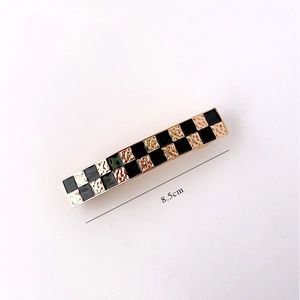 Detailed macro view of an 8.5cm checkerboard hair clip with gold hammered texture