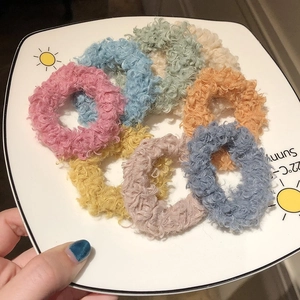 Set de 7 gomas de pelo de forro polar esponjoso en tonos pastel sobre bandeja de cerámica