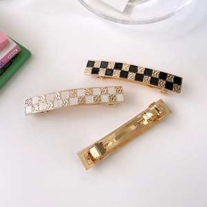 Checkboard pattern hair clip with black and white enamel finish on metal spring base