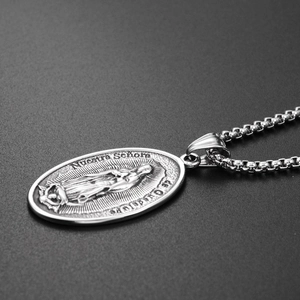 Detalle macro del colgante ovalado con relieve de la Virgen de Guadalupe en plata