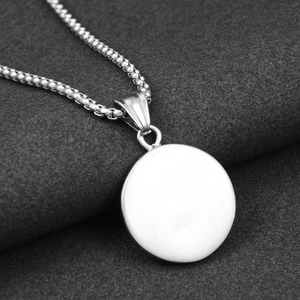 Close-up of minimalist stainless steel compass pendant with a sleek box chain design