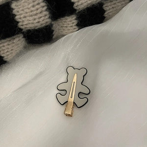 Barrette à cheveux ours gris en acrylique avec fermoir métallique sur tissu blanc