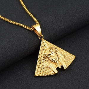 Macro view of gold pyramid pendant with detailed pharaoh relief and sturdy box chain link
