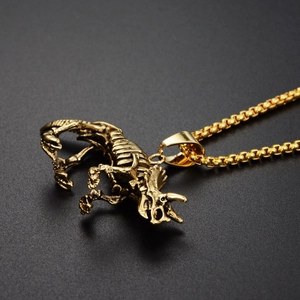 Gros plan du pendentif squelette de tricératops doré avec texture rétro sur chaîne