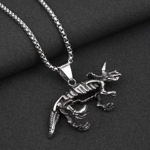 Détail d'un pendentif squelette de tricératops vintage avec une chaîne à mailles carrées