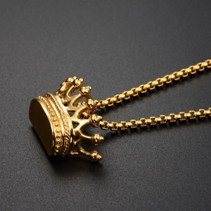 Detailaufnahme eines goldenen Kronenanhängers mit feinen Texturen und Boxkette
