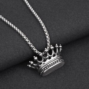 Makroaufnahme von Silberkronen-Anhänger an Box-Kette mit feinen Vintage-Stahldetails