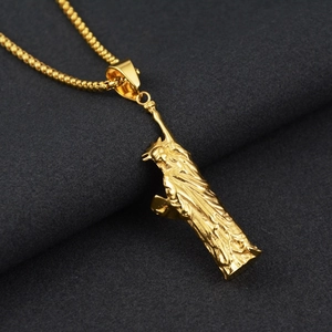 Vue macro du pendentif Statue de la Liberté plaqué or avec chaîne sur tissu velours